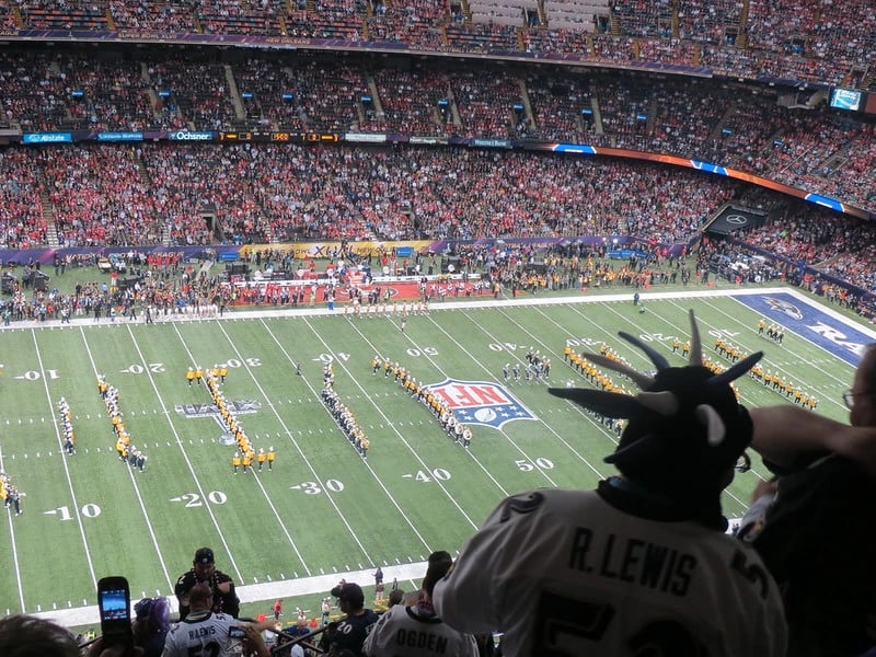 Packed stadium during Super Bowl XLVII with the field filled by performers forming shapes around the NFL logo during the pregame ceremony.