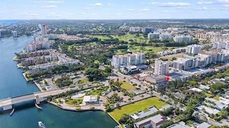 Aerial view of East Boca waterfront with a bridge, waterways, residential buildings, and green spaces.