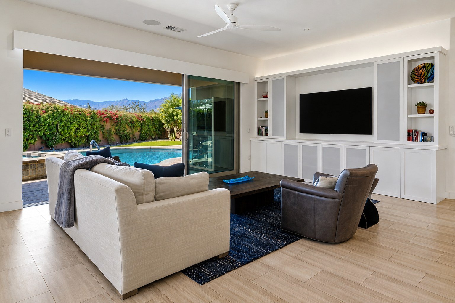 Great room with sliders open to the pool and mountain view at Trilogy at The Polo Club