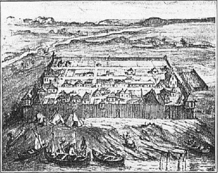 Fortified riverside settlement with a wooden palisade and boats in the foreground.