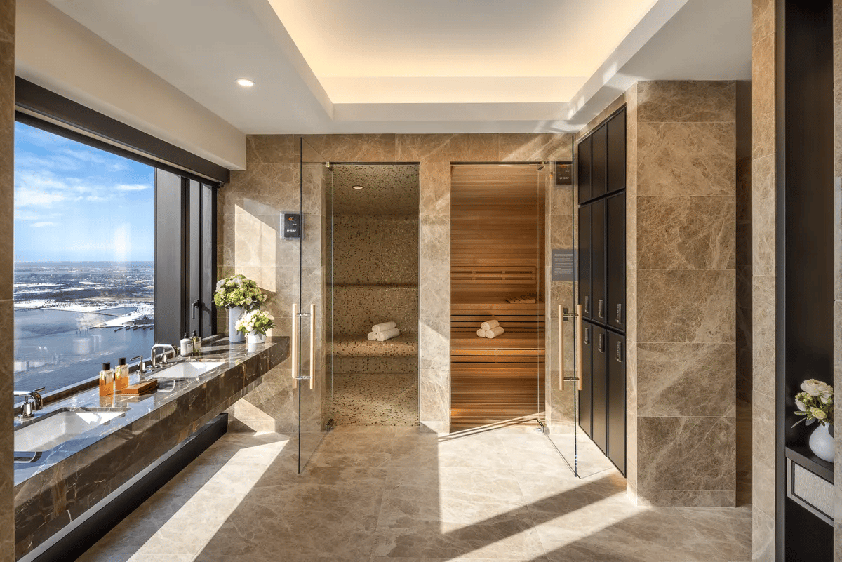 Marble bathroom with twin sinks, river views, glass steam shower, and wood sauna.
