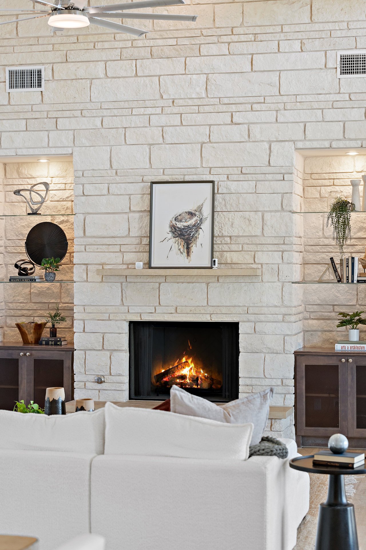 Stone fireplace detail with built-in display niches in the living room of this Caudill Lane home in the Bee Caves area of Austin, Texas.