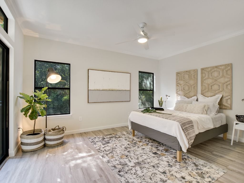 Primary bedroom with a ceiling fan and wood-look flooring at 1000 Liberty Park Drive #203, Liberty Park Condominiums, Westlake, Austin, TX 78746.