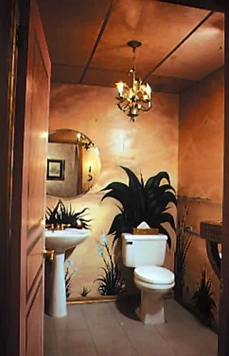Bathroom with a white toilet, pedestal sink, leafy plants, and a chandelier.