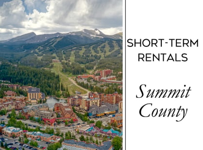 Short-term rentals in Summit County, with an aerial view of a mountain town and surrounding mountains.