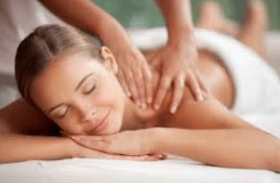 A woman receives an upper-back and shoulder massage while lying face down.