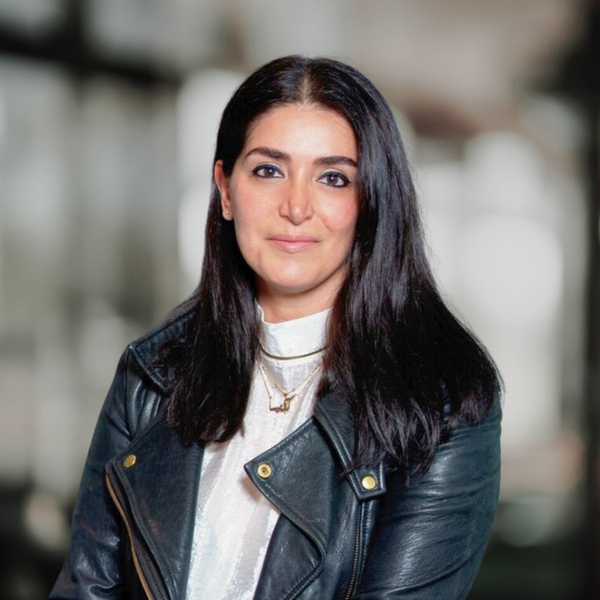 Avissa Mojtahedi wearing a black leather jacket and layered gold necklaces.