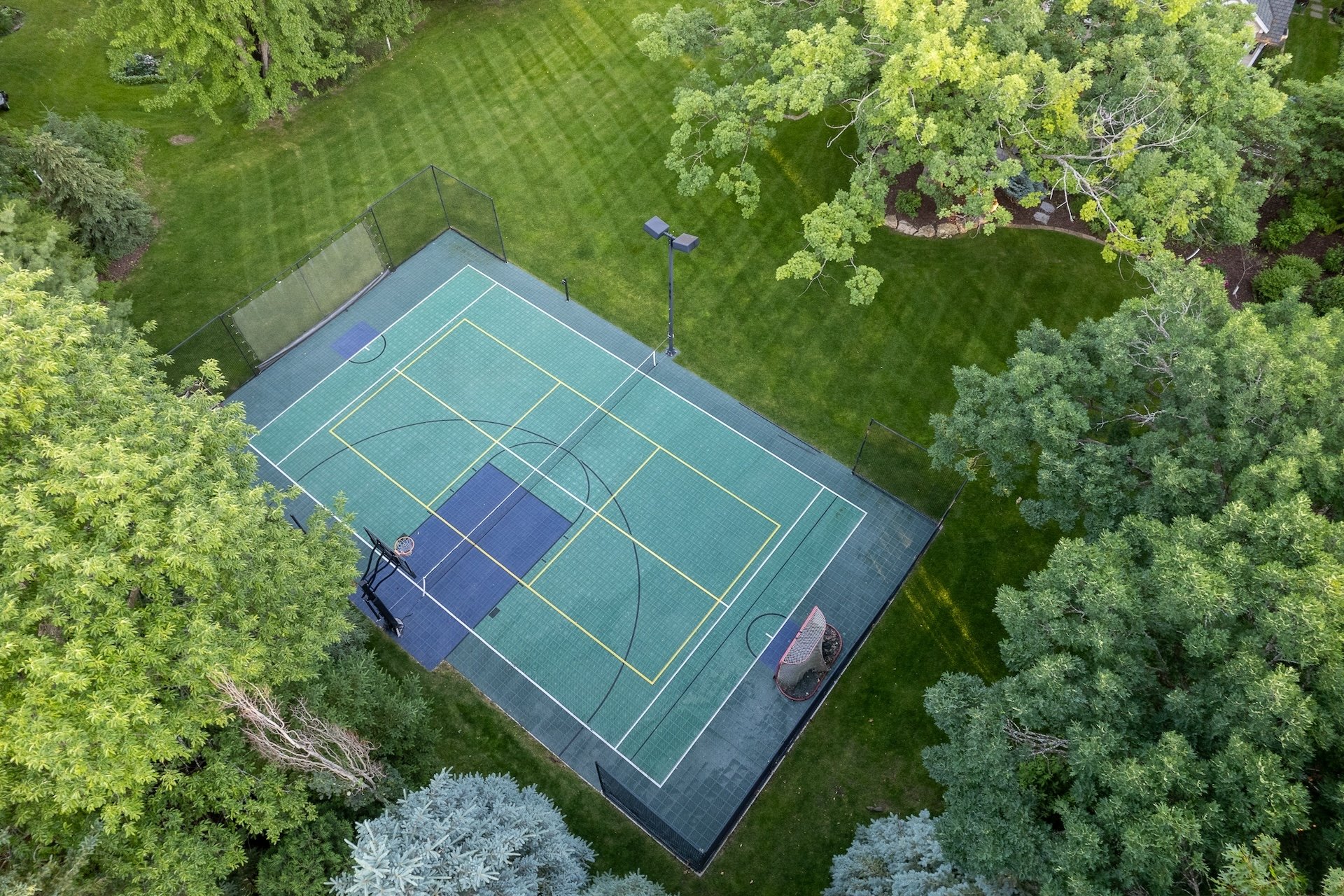 Aerial view of a large Parkwood Knolls lot with sport court, mature trees, and deep backyard