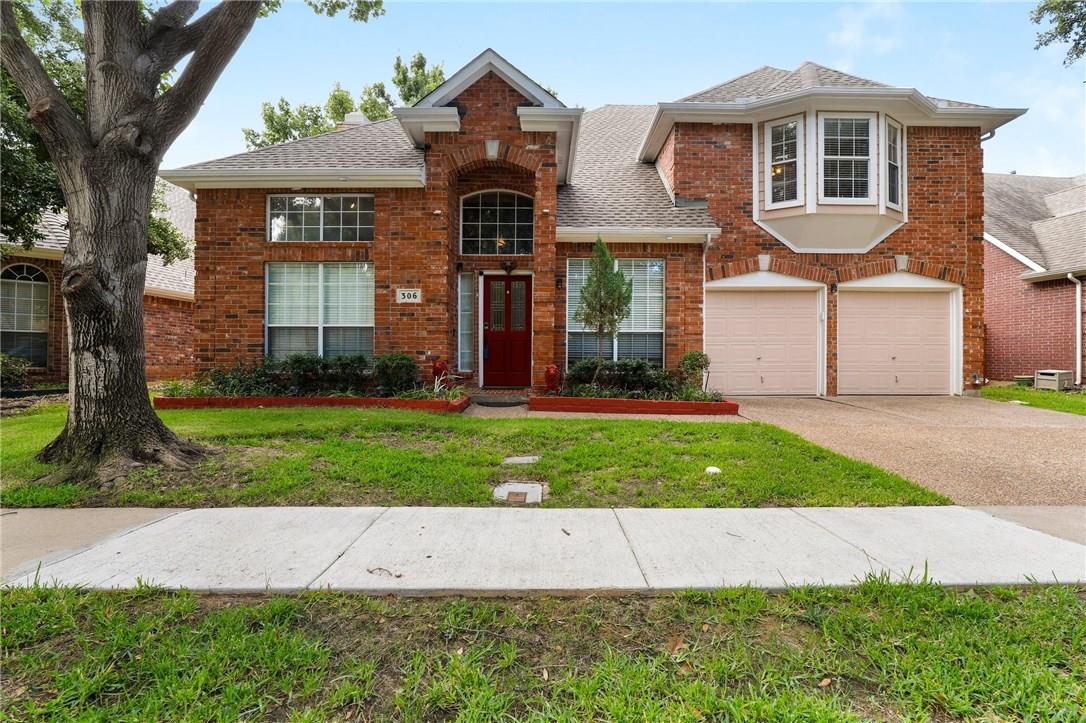 Two-story red-brick house with a red front door, bay window, and two-car garage.