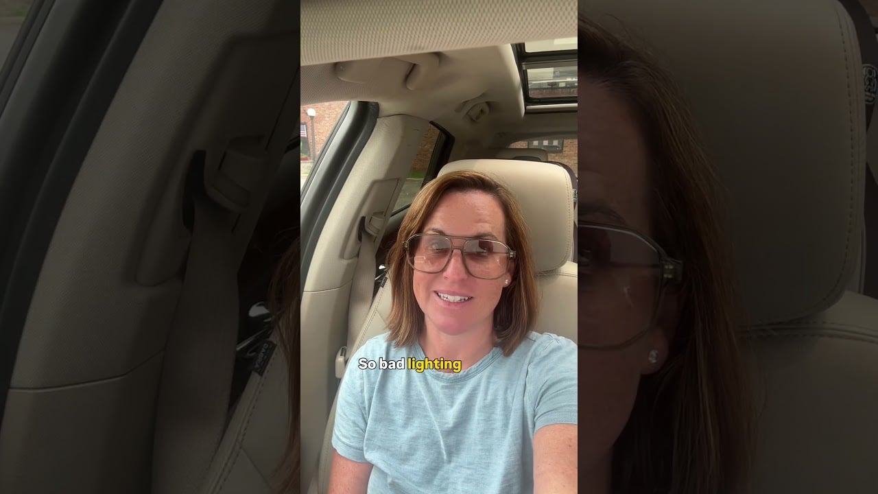 Melissa Infanzon seated in a car, wearing large glasses and a light blue shirt.