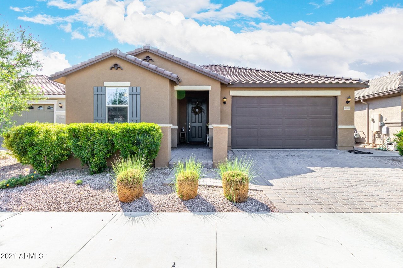 Single-story stucco home with a tiled roof, two-car garage, and desert landscaping.