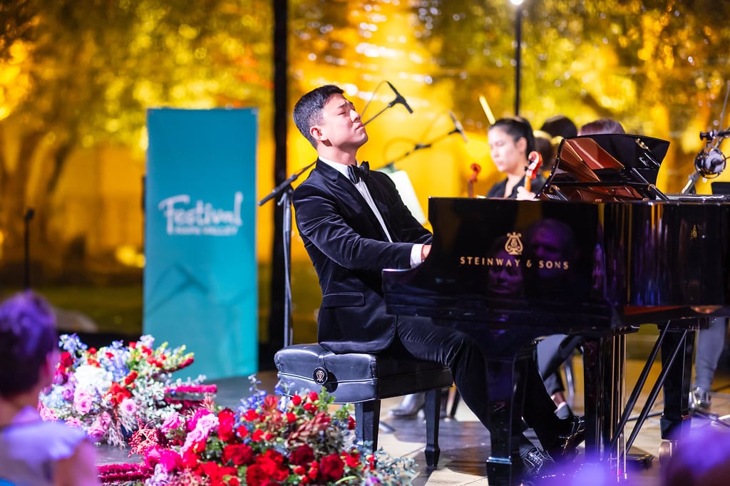 Pianist Yang Bao performs on a Steinway grand piano during a Festival Napa Valley concert as an audience watches from the foreground.
