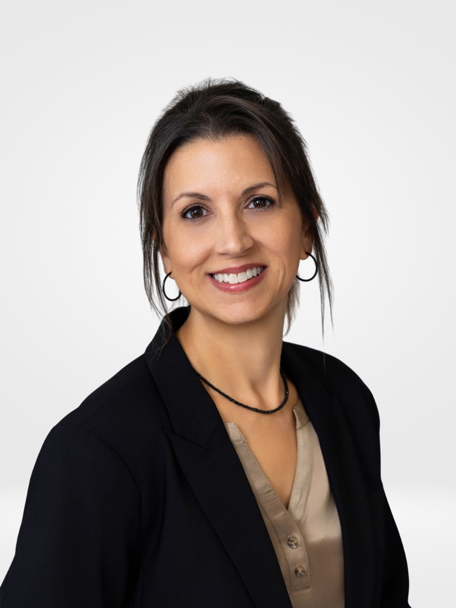 Tracy Scarbrough smiling in a black blazer and beige blouse.