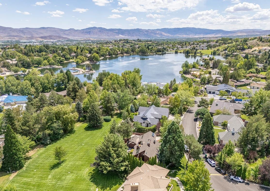  Lake Ridge Shores community of southwest Reno. This split-level residence is more than a home - it's an experience - where every angle, finish, and feature has been intentionally designed to delight. Step inside to find a balance of hardwood and ceramic tile flooring, anchored by soaring redwood-finished ceilings that highlight striking architectural lines and flood the space with natural light. A remarkable live green planter with a fountain feature runs the full length of the home, bringing the outdoors in and creating a sense of calm and connection.