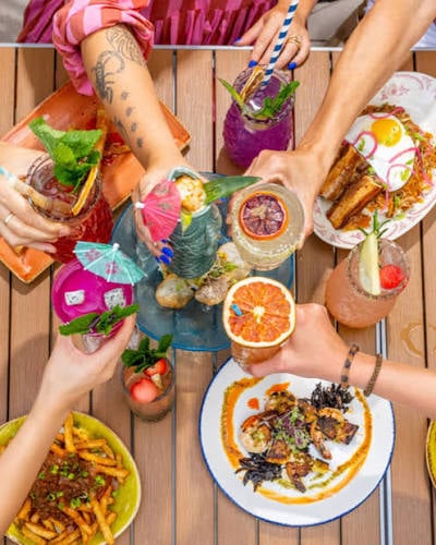 Shared plates and colorful cocktails at a lively dining table