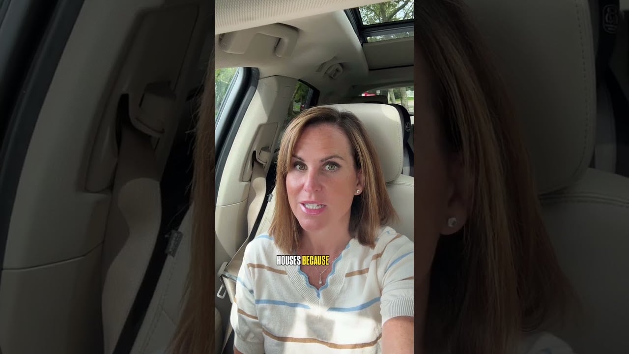 Woman speaking to camera in a car, wearing a striped top with cream leather seats behind her.