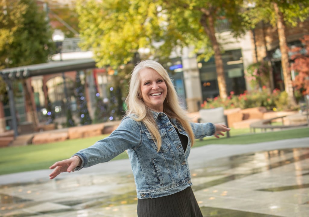Sharla Jolley Ellis standing in front of a modern condo building, representing expert guidance in condo lending and mortgage approvals.