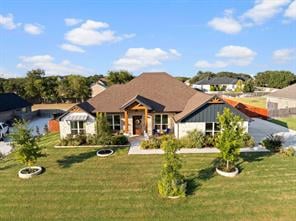 Single-story home with a brown roof, covered porch, and landscaped front lawn.