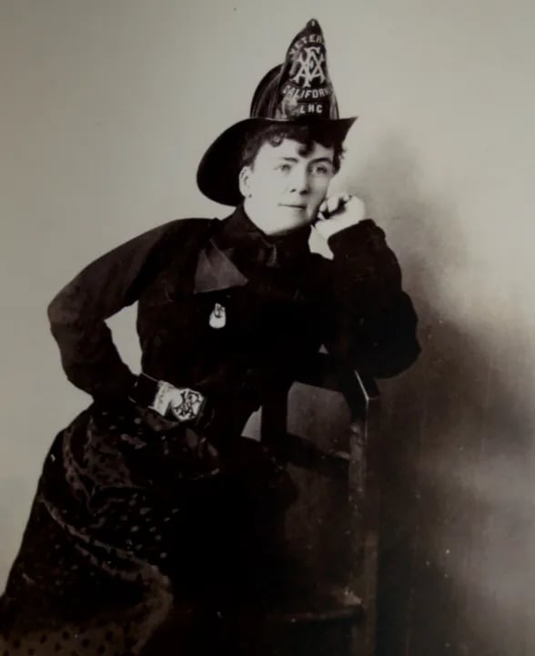 Lillie Hitchcock Coit in vintage firefighter uniform and helmet, black and white portrait photograph
