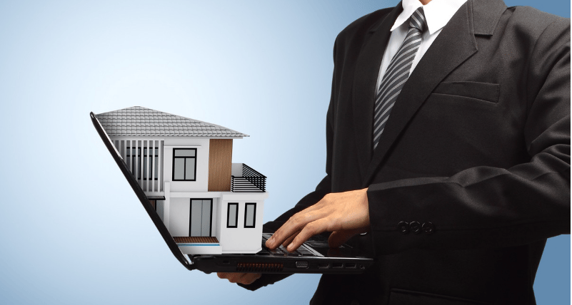 Businessperson using a laptop displaying a modern house