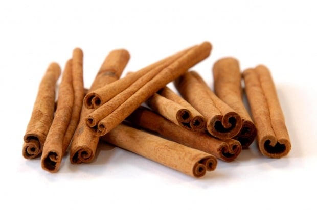 Cinnamon sticks piled on a white surface