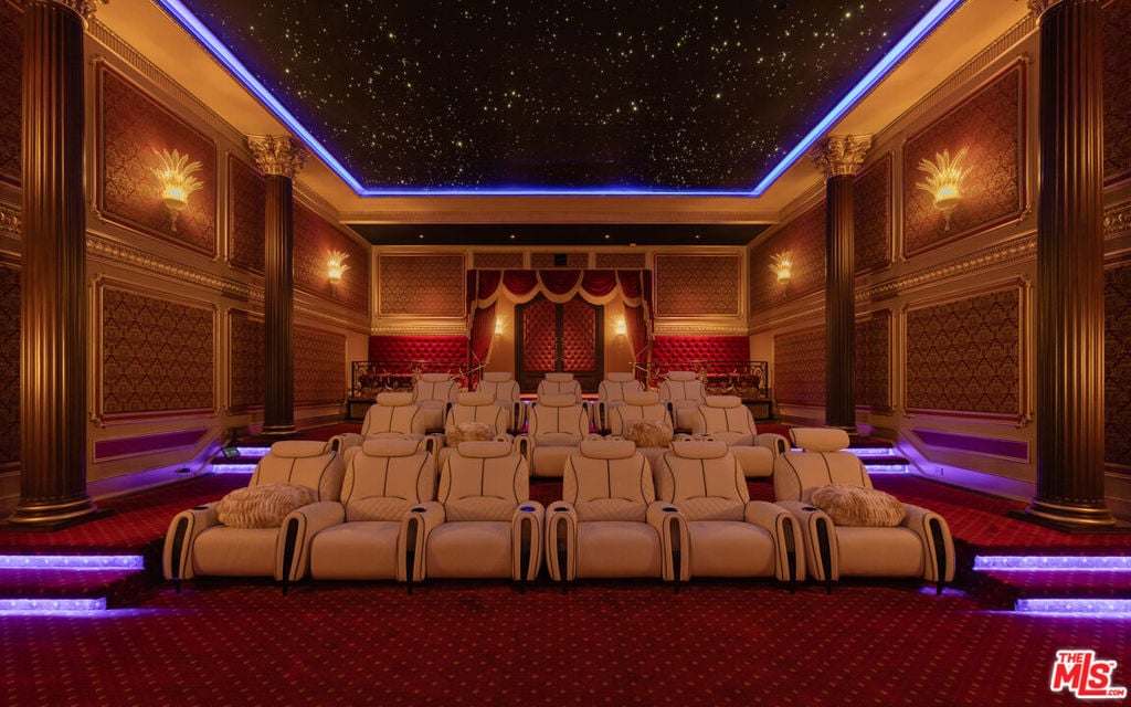 Home theater with cream reclining seats, ornate red-and-gold walls, and a starry ceiling.