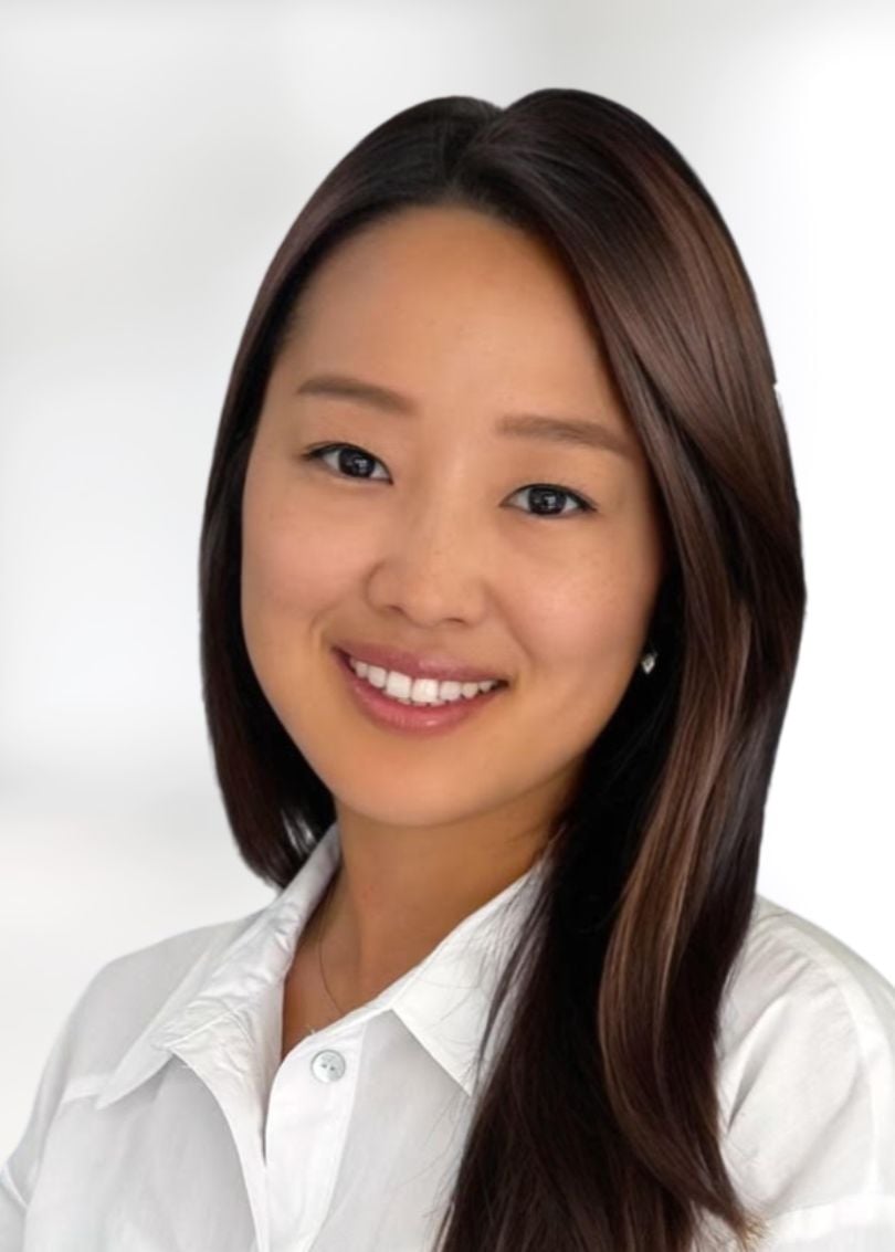 Allison Lee smiling in a white collared shirt.