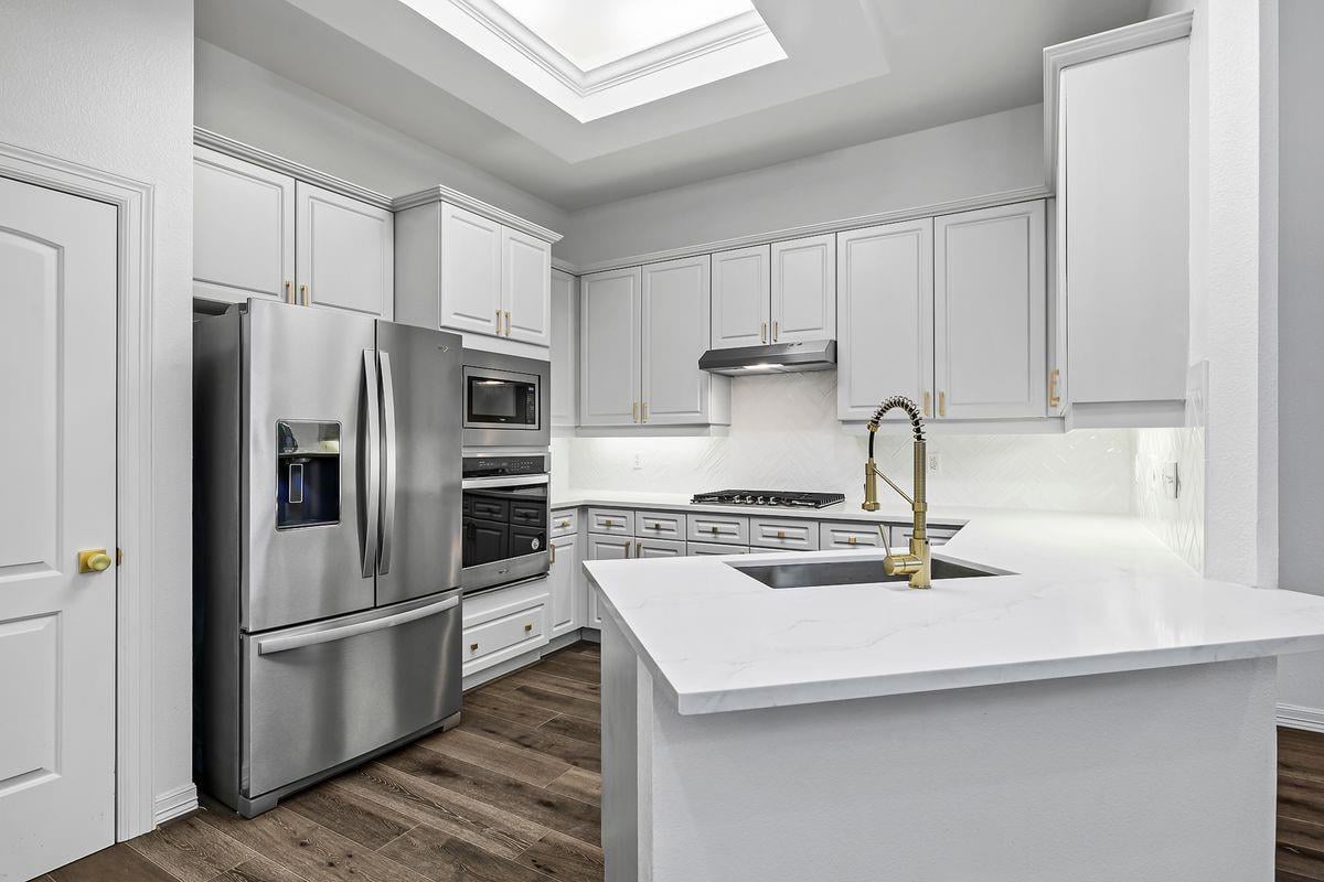Kitchen with quartz island, brass faucet, and stainless refrigerator, Barton Hollow, Westlake, Austin.