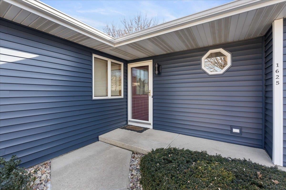 The covered front entry of a single level Madison home with a flat walkway and a single low step, the kind of ground level access many buyers are looking for when they say they want one-level living.