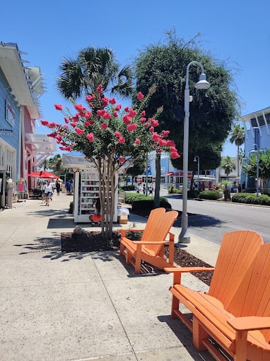 Colorful Adirondack chairs and palm trees along the street at Pier Park in Panama City  Beach Florida