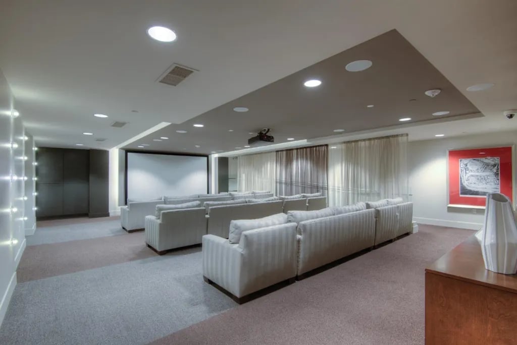 A screening room at the Madrone, equipped with multiple rows of comfortable seating and a large projector screen for movie nights.
