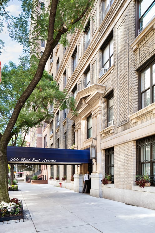 Exterior of 500 West End Avenue, with a blue entrance awning and leafy sidewalk trees.