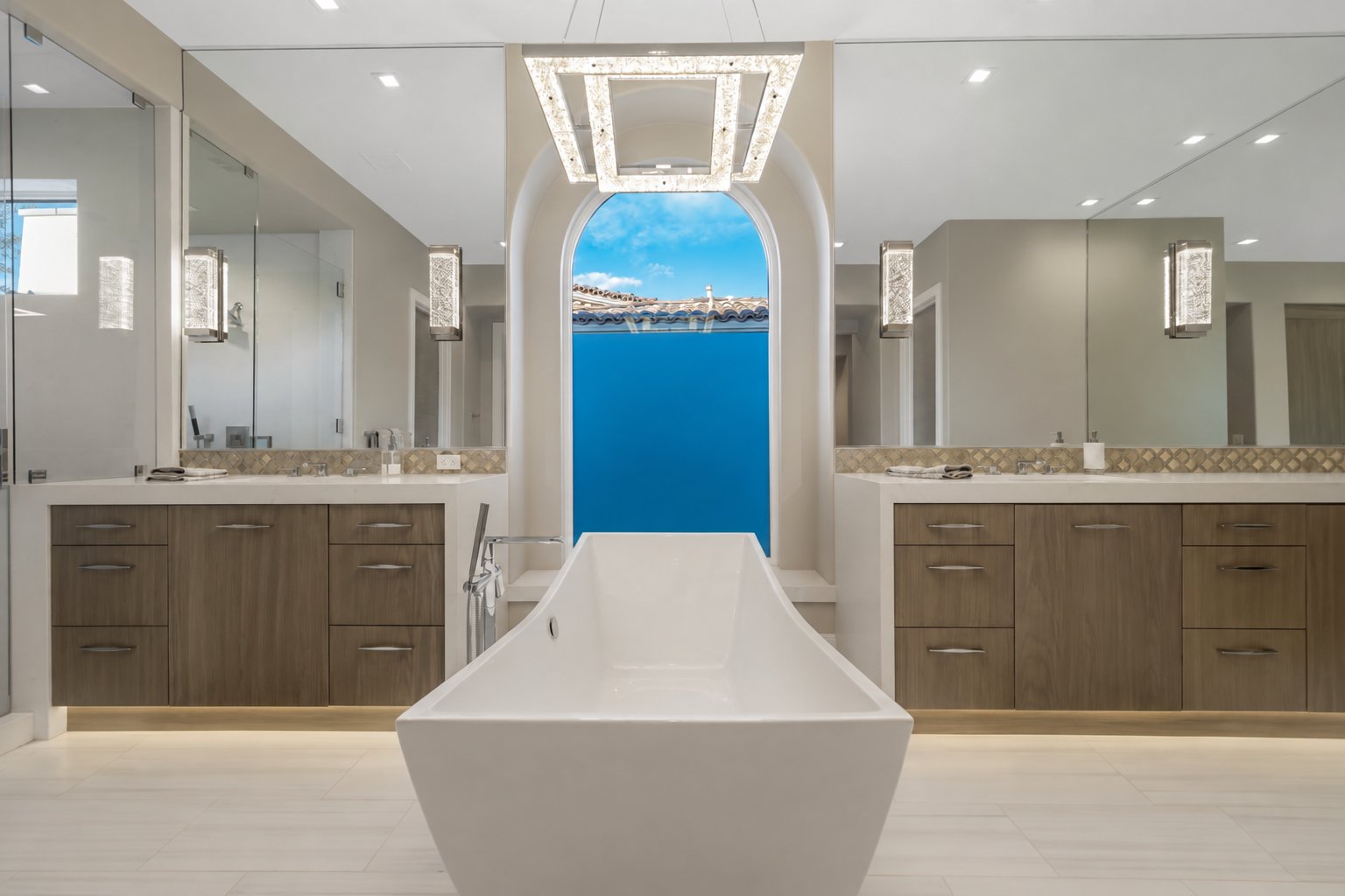 Primary bathroom with freestanding tub under an arched window at Toscana Country Club