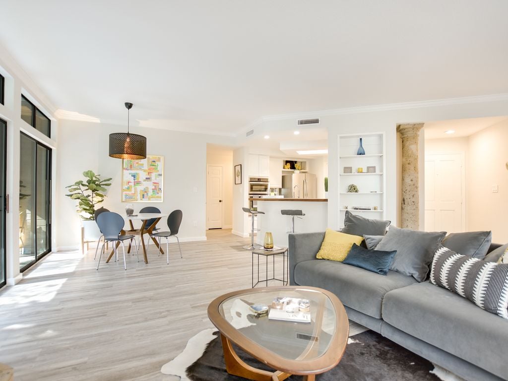 Open-concept living, dining, and kitchen space with a decorative stone column and a breakfast bar at 1000 Liberty Park Drive #203, Liberty Park Condominiums, Westlake, Austin, TX 78746.