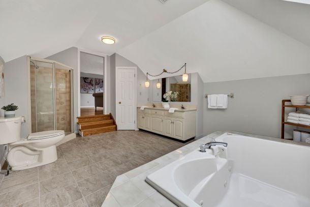 Spacious bathroom with a corner soaking tub, glass shower, and double vanity.