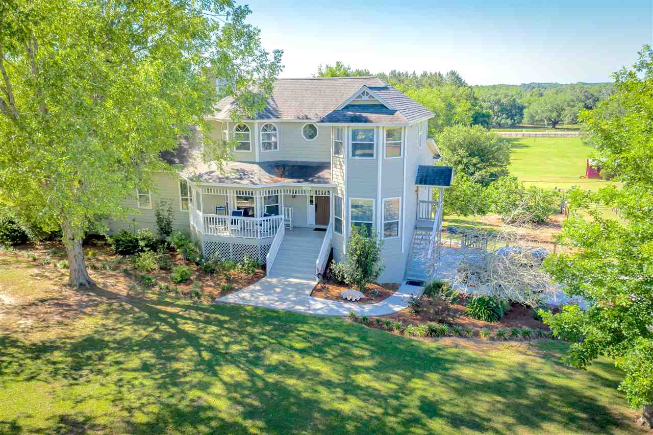 A spacious home surrounded by a large yard and lush trees, creating a serene and inviting outdoor environment.