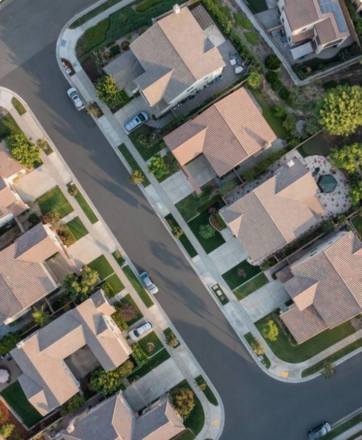 Aerial view of a residential neighborhood with tiled-roof homes and landscaped yards.