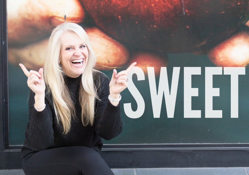 “Sharla Ellis smiling in front of a bright, modern apple backdrop, highlighting sweet opportunities for buyers through seller credits, temporary buydowns, and creative homeownership strategies.”
