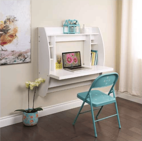 Home office with a white wall-mounted desk, laptop, and turquoise folding chair.