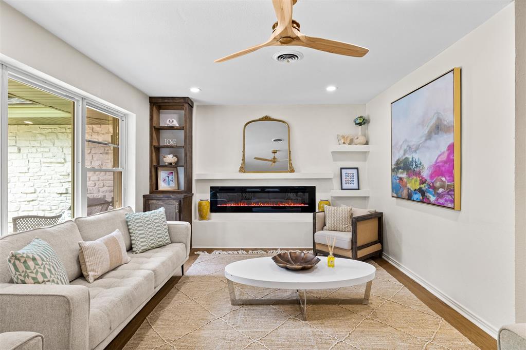 Living room with a linear fireplace, cream sofa, built-in shelves, and large windows.