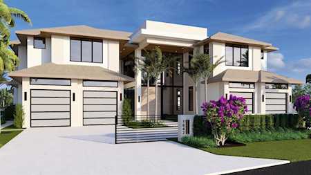 Modern two-story home with multiple garage doors, broad entry steps, and landscaped gardens.