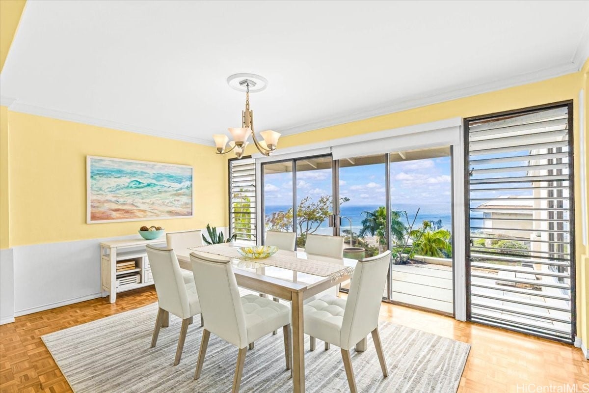 Staged dining room with yellow walls and sliding doors overlooking the ocean.