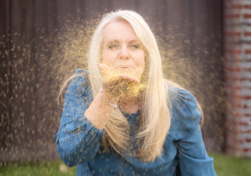 Sharla Ellis blowing glitter to symbolize a New Year clean slate, setting goals, intention, and fresh beginnings