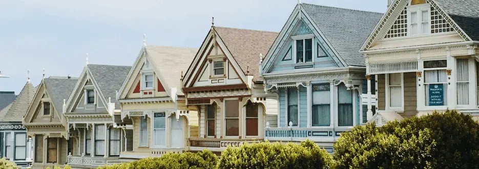 Colorful Victorian-style houses with ornate trim and steep gabled roofs
