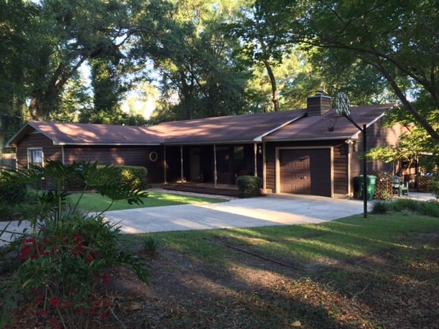 A spacious home surrounded by a large yard and mature trees, creating a serene and inviting outdoor environment.