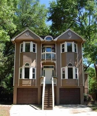 A two-story home featuring a spacious porch and prominent stairs leading to the entrance.