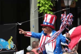 Man in an Uncle Sam-style outfit points amid American flags and patriotic decorations.