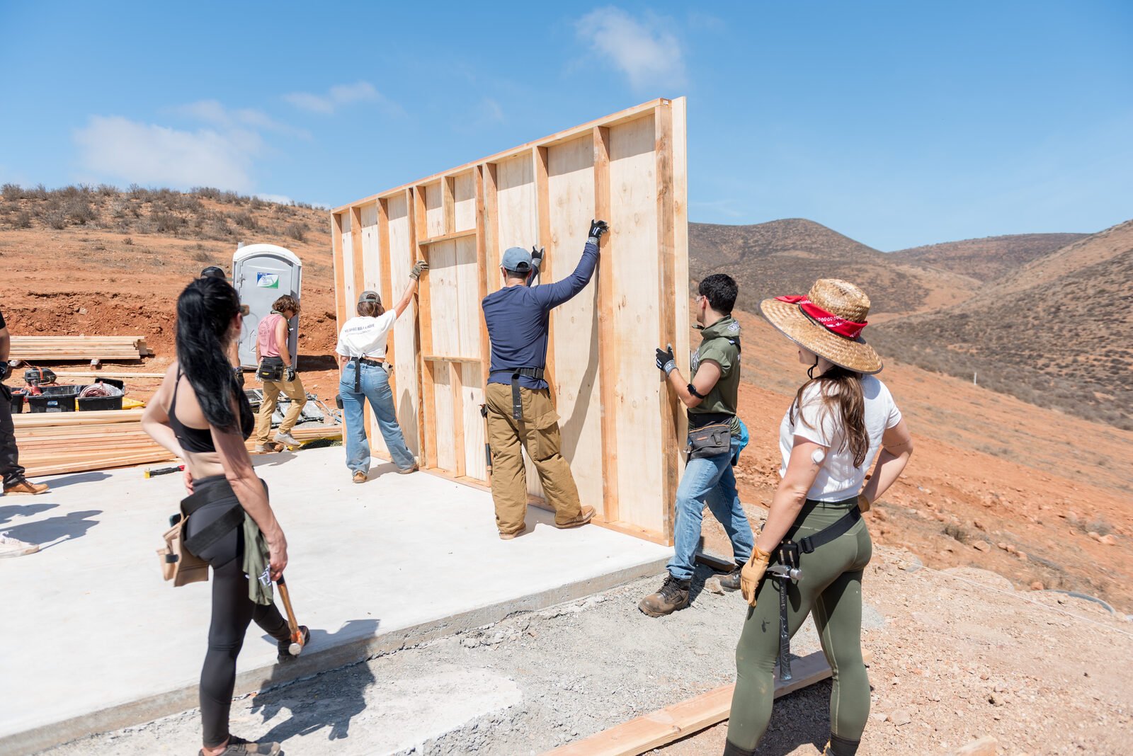 Volunteers raising a framed wall at the Impact MVMT house build in Baja California