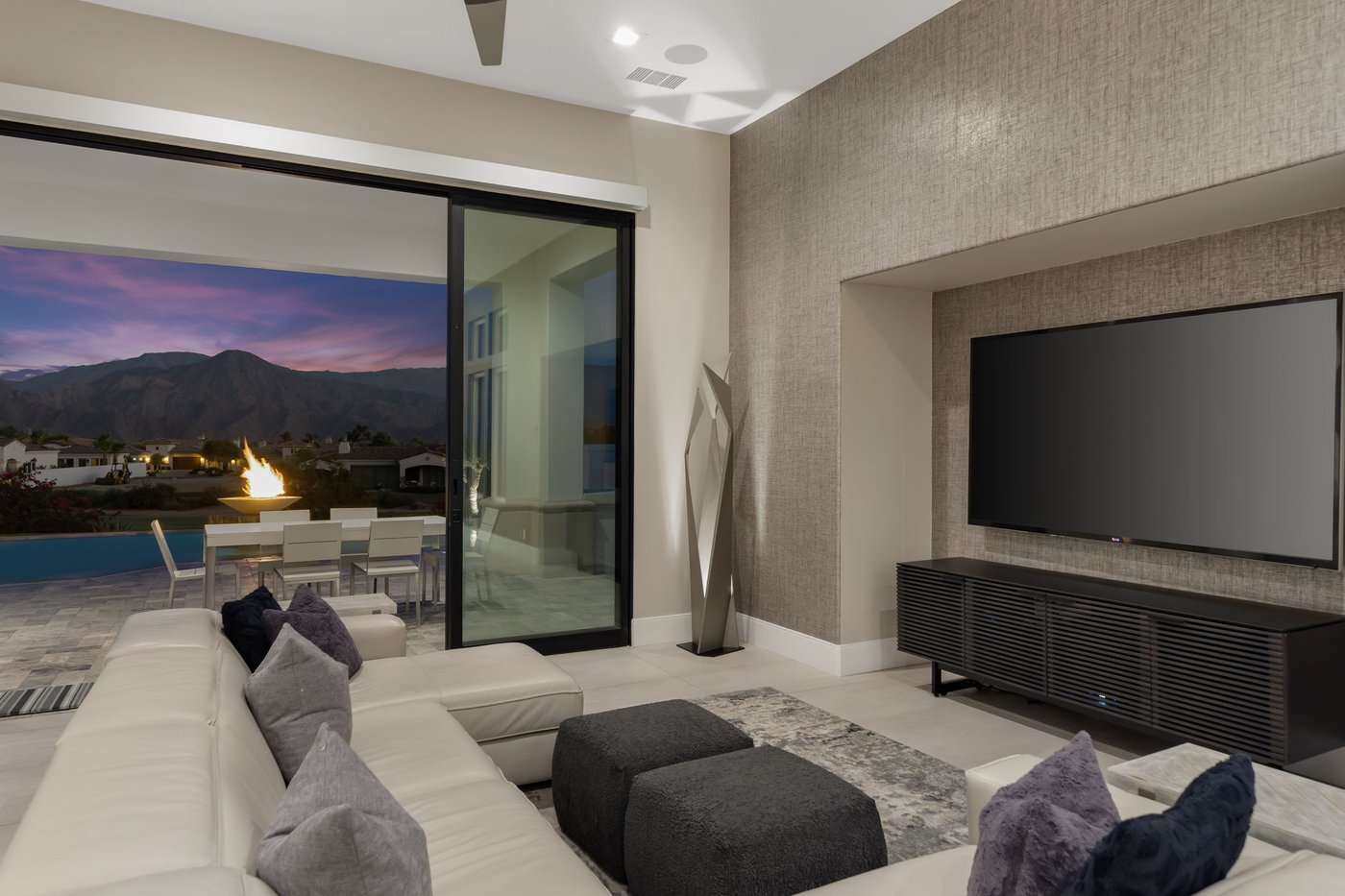 Great room at twilight with fire bowl and mountain view at Toscana Country Club
