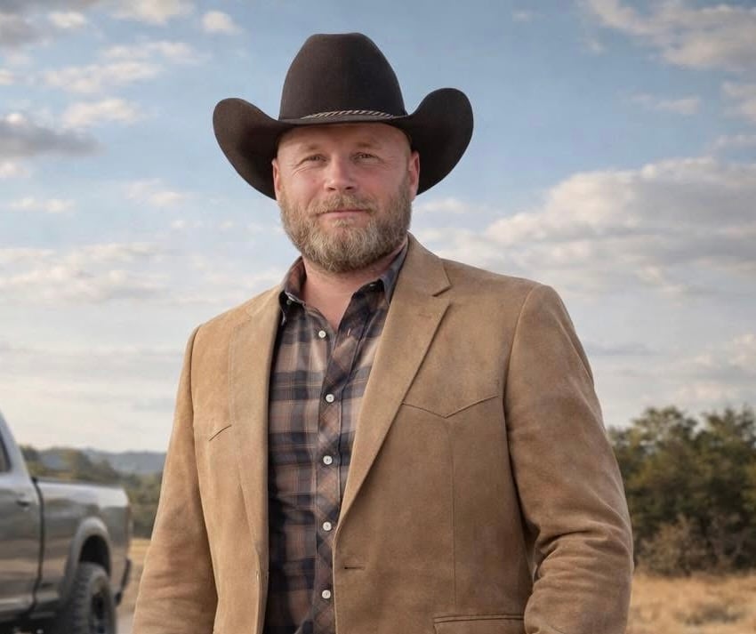 Brian Collier wearing a black cowboy hat and tan blazer outdoors.